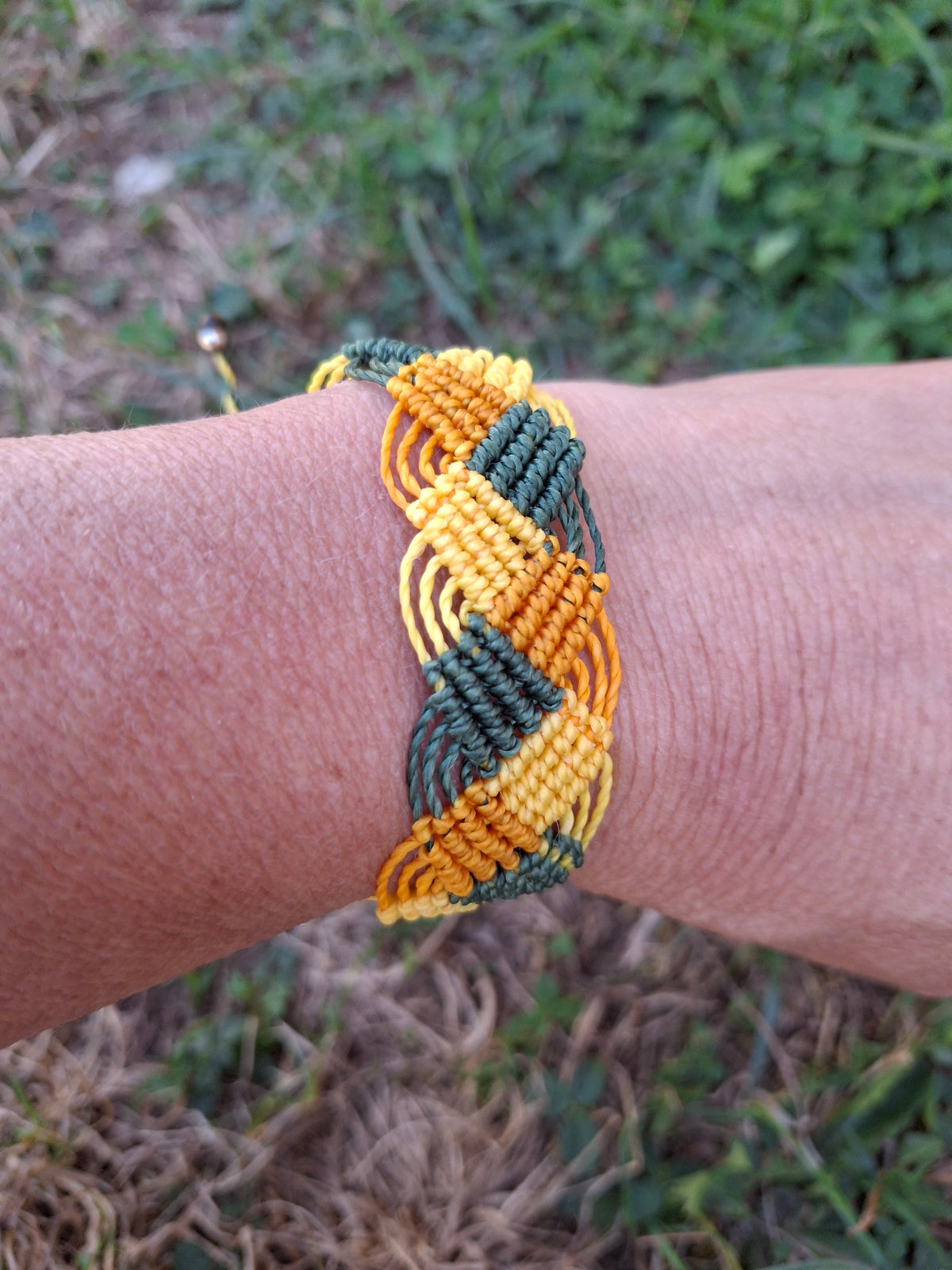bracelet tissé à a main en micro macramé modèle @solyluna fil @linhasita de couleur jaune mandarine et vert bouteille