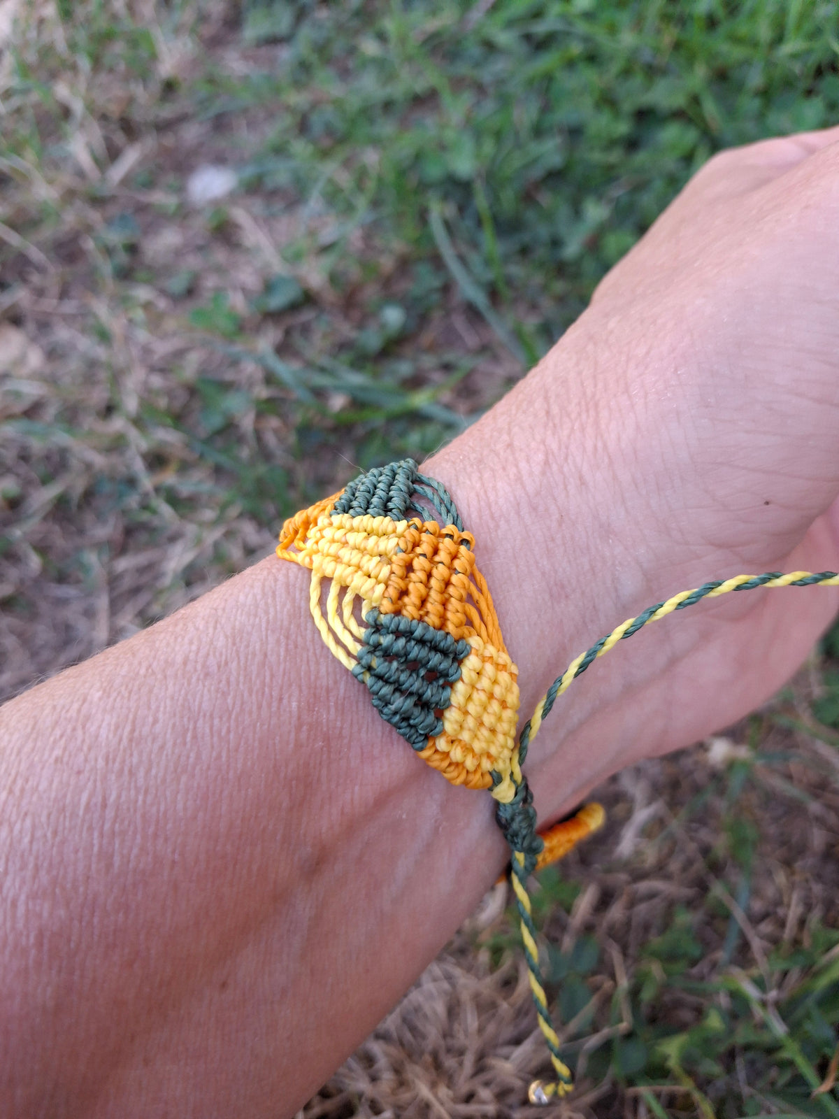 bracelet tissé à a main en micro macramé modèle @solyluna fil @linhasita de couleur jaune mandarine et vert bouteille