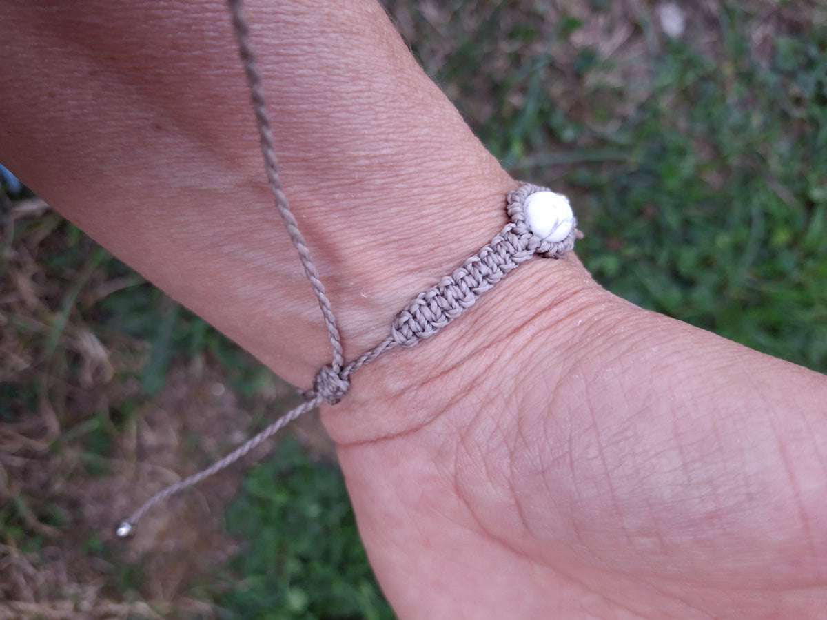 bracelet tissé à la main en micro macramé de couleur gris clair avec 5 perles en howlite ainsi que des perles en acrylique argenté