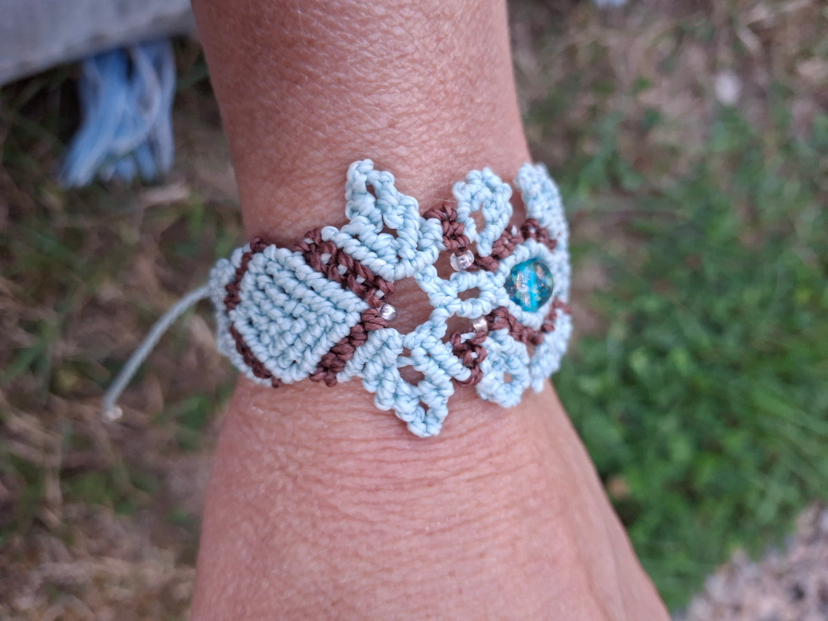 bracelet tissé à la main en micro macramé de couleur menthe et chocolat avec une perle fluorescente  en verre  bleu et des perles de rocailles fluorescente 