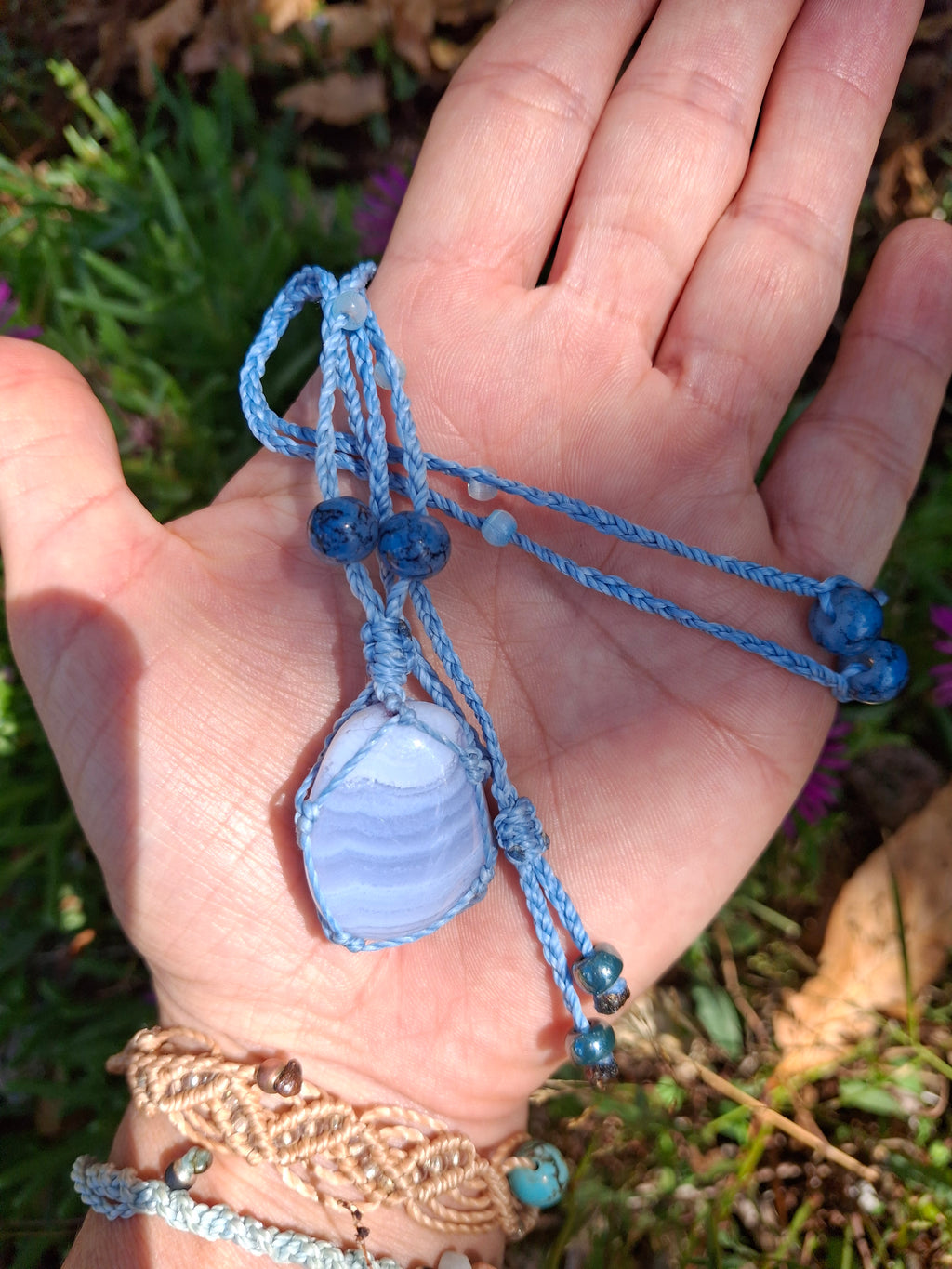 calcédoine roulée tissé en filet à la main en micro macramé de couleur bleu ciel et des perles en verre
