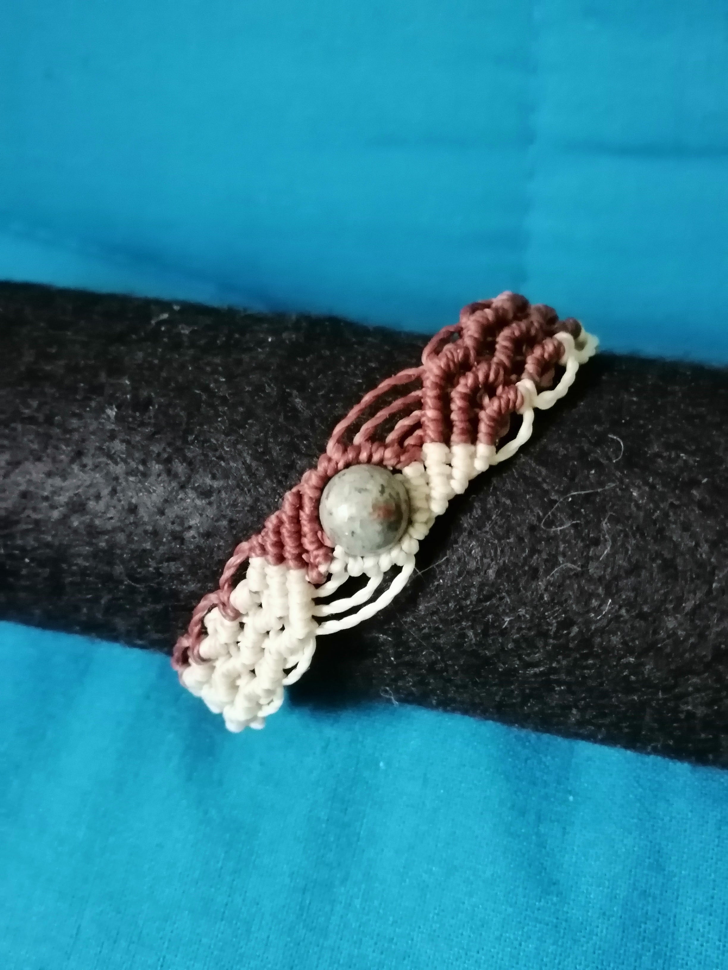 bracelet modèle @solyluna tissé a la main en micro macramé de couleur chocolat et beige avec une perle en yooperlite.