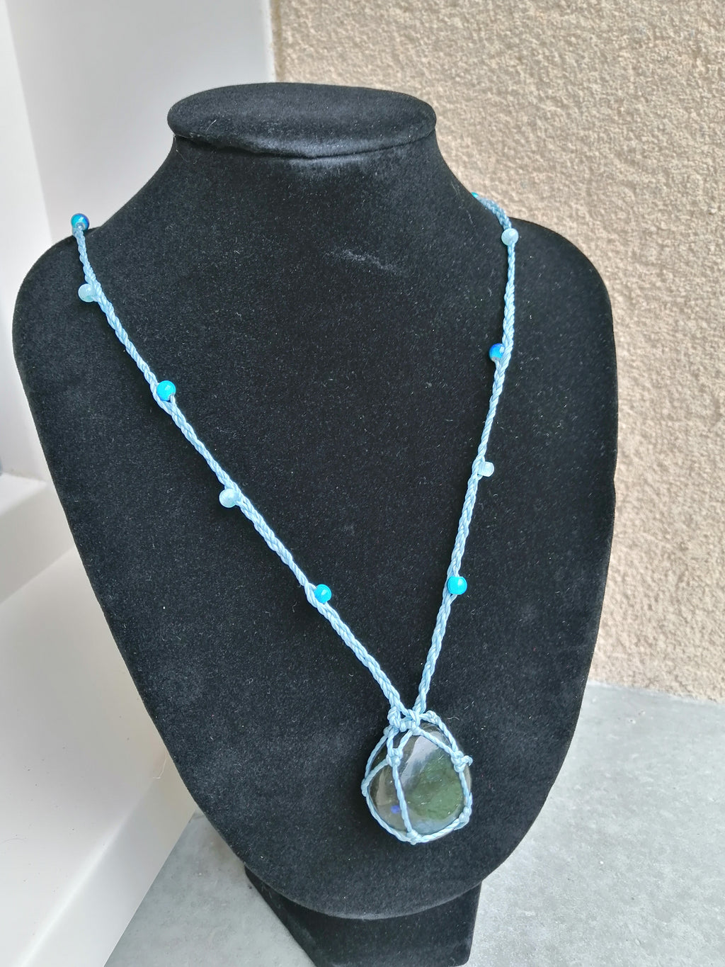 sautoir tissé a la main de couleur bleu ciel avec des perles en verre, des perles réfléchissante et un pierre en labradorite.