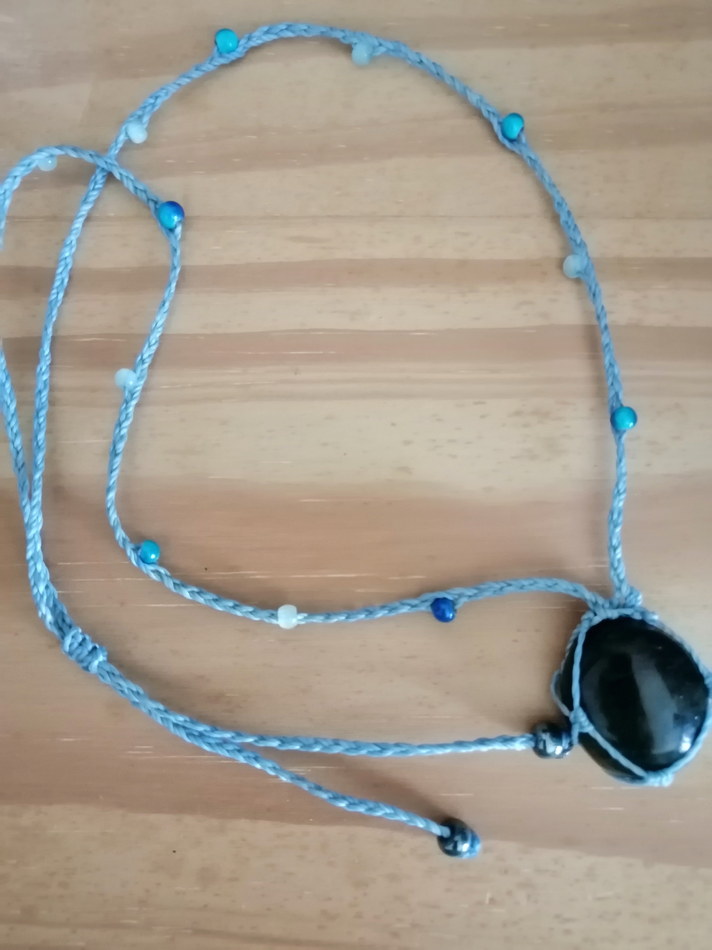 sautoir tissé a la main en micro macramé de couleur bleu ciel avec des perles en verre, des perles réfléchissante et une pierre en labradorite bleu.