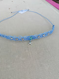 choker tissé à la main en micro macramé de couleur bleu ciel avec 3 tortue de chaque coté et en son centre une perle fluorescente de couleur bleu de 8mm avec une étoile de mer