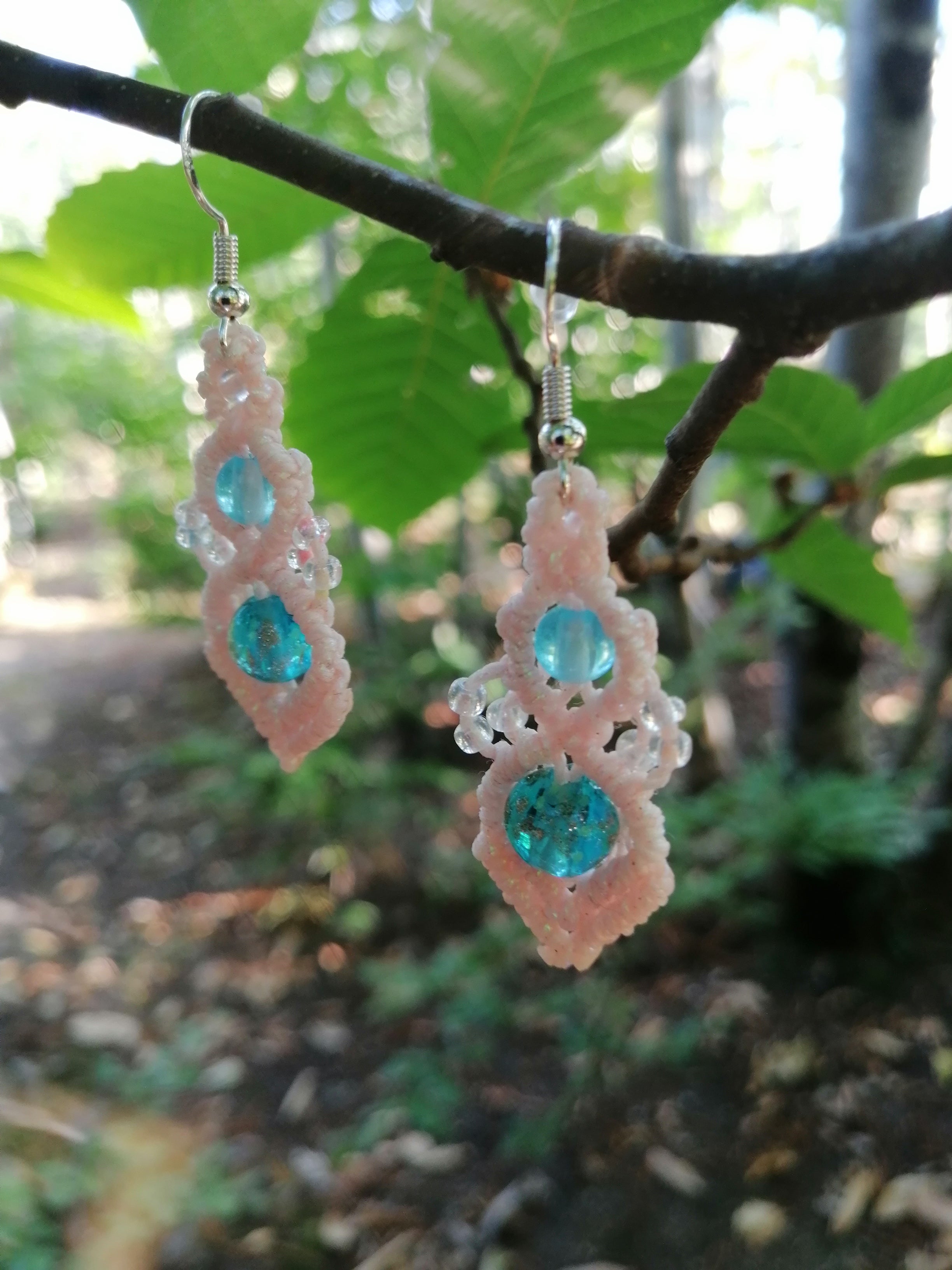 Boucle d'oreille tissé à la main en micro macramé de couleur rose avec des perles fluorescentes