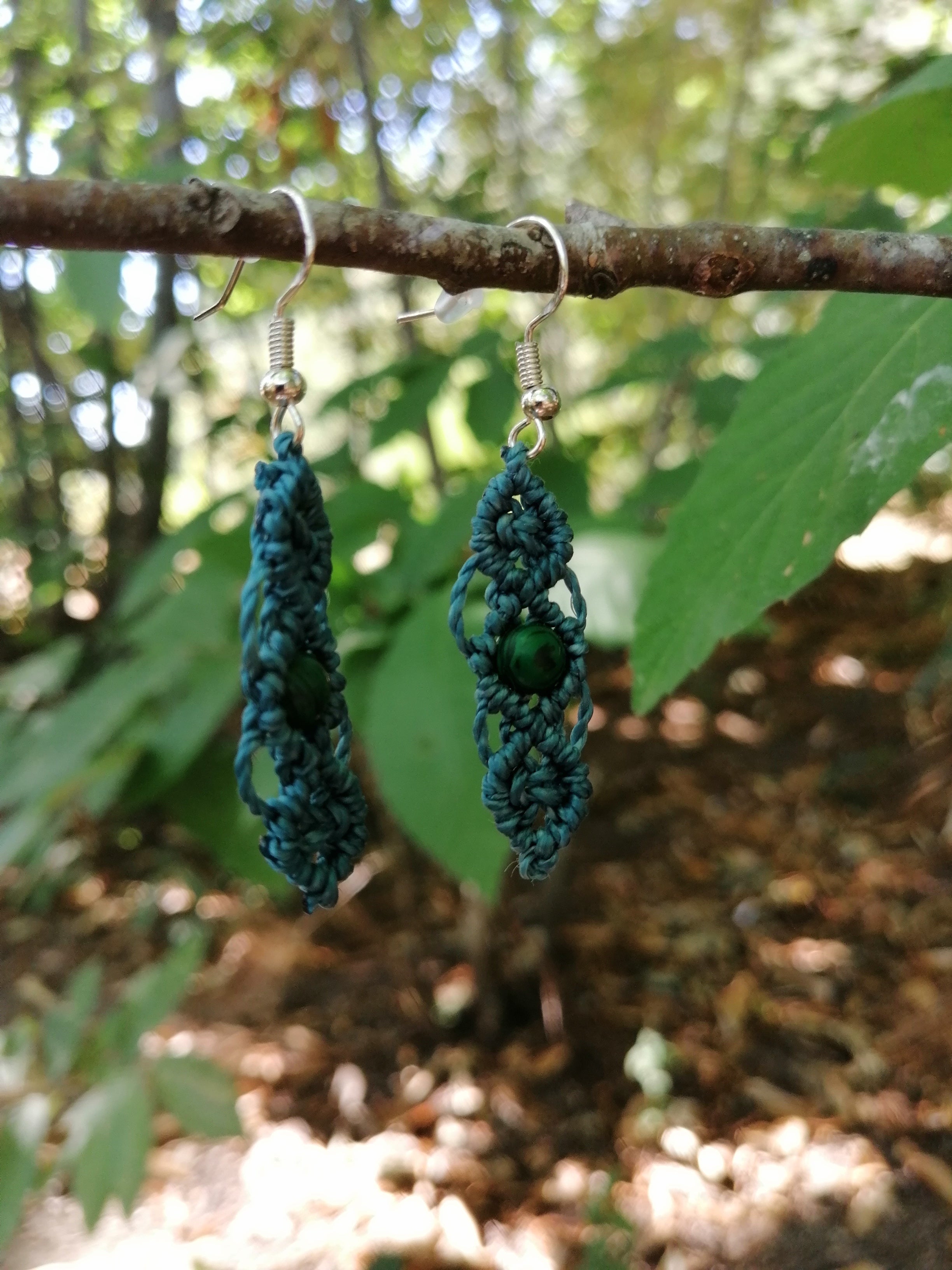 Boucle d'oreille tissé à la main  en micro macramé, de couleur bleu canard, avec une perle verte