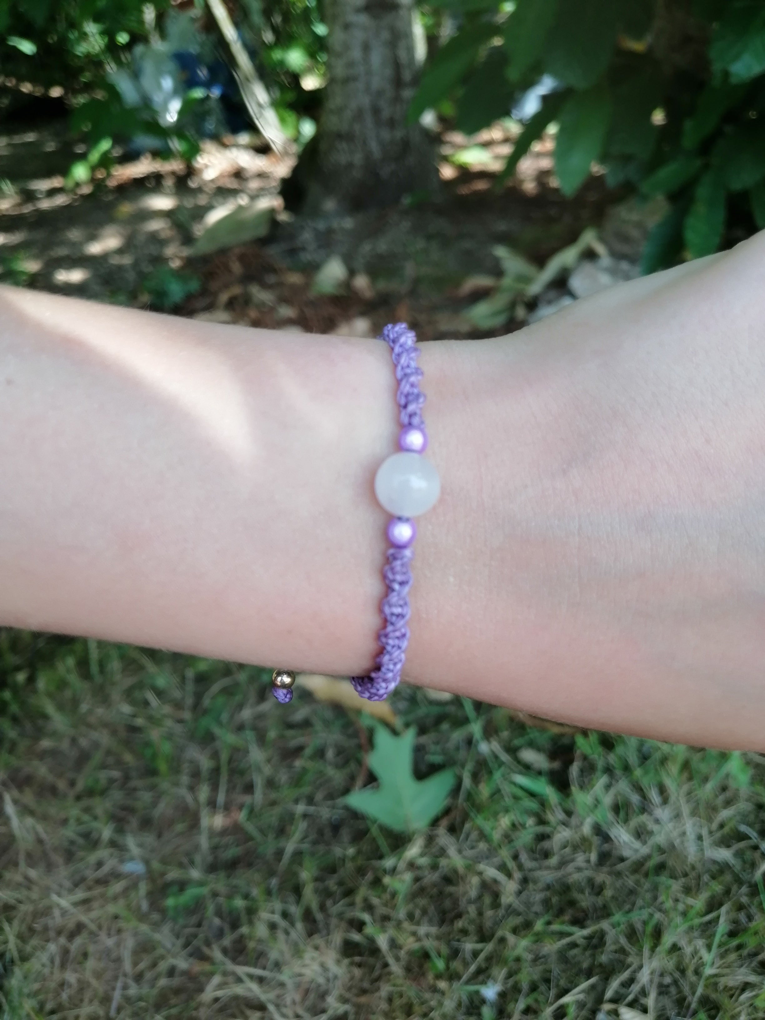 bracelet enfant tissé à la main en micro macramé de couleur mauve avec une perle en  quartz rose et 2 perles réfléchissante de couleur mauve