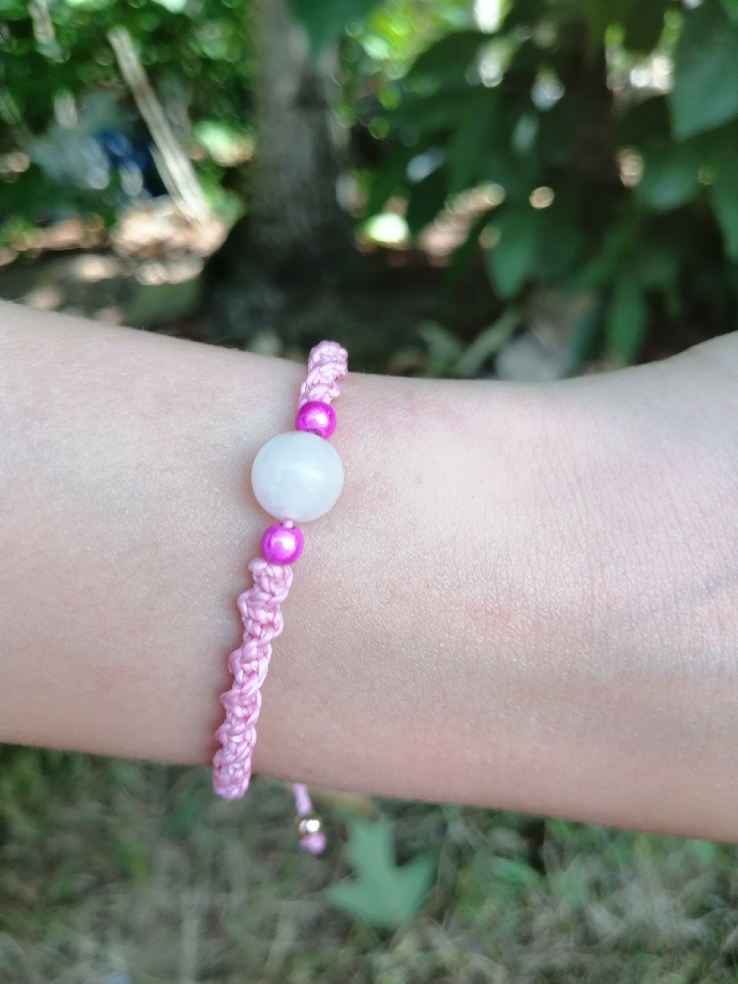 bracelet enfant tissé à la main en micro macramé de couleur bois de rose avec une perle en quartz rose et 2 perles réfléchissante rose