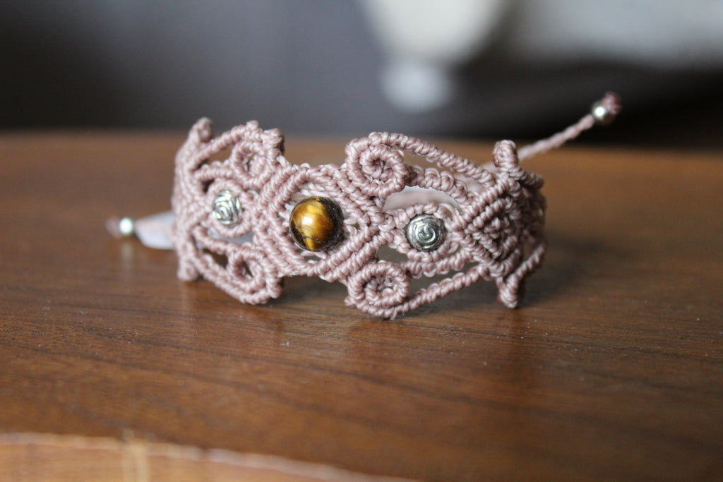 bracelet modèle @lesfilsambulants tisé a la main en micro macramé de couleur taupe et une perle en oeil de tigre.