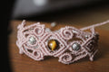 bracelet modèle @lesfilsambulants tissé a la main en micro macramé de couleur taupe avec des perles en acrylique et une perle en oeil de tigre.