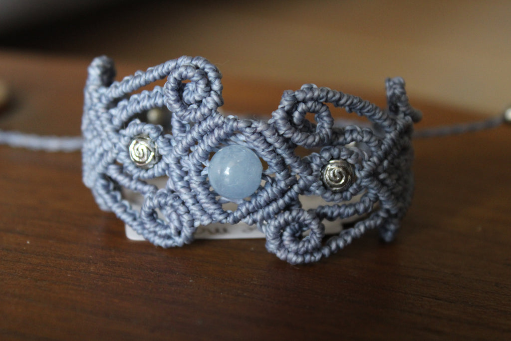 bracelet tissé a la main  en micro macramé de couleur bleu tendre avec  des perles en acrylique don 2 en forme de rose et une perle en aigue marine.