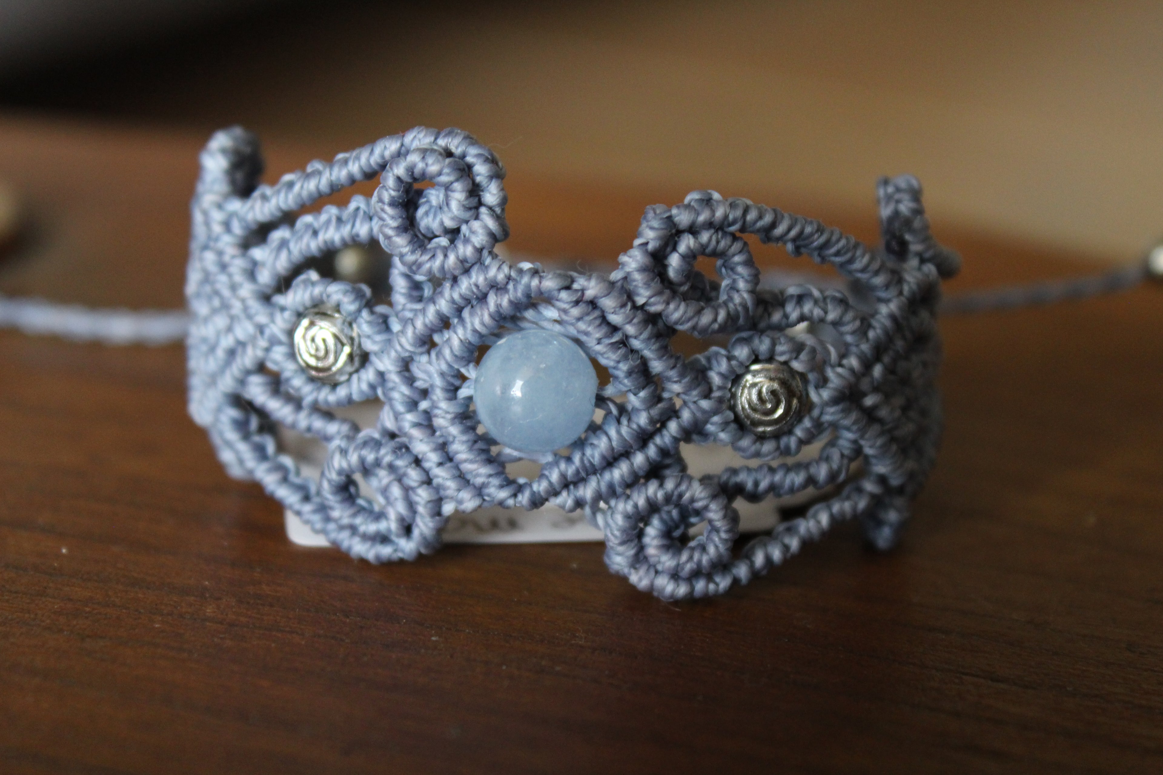 bracelet tissé a la main  en micro macramé de couleur bleu tendre avec  des perles en acrylique don 2 en forme de rose et une perle en aigue marine.