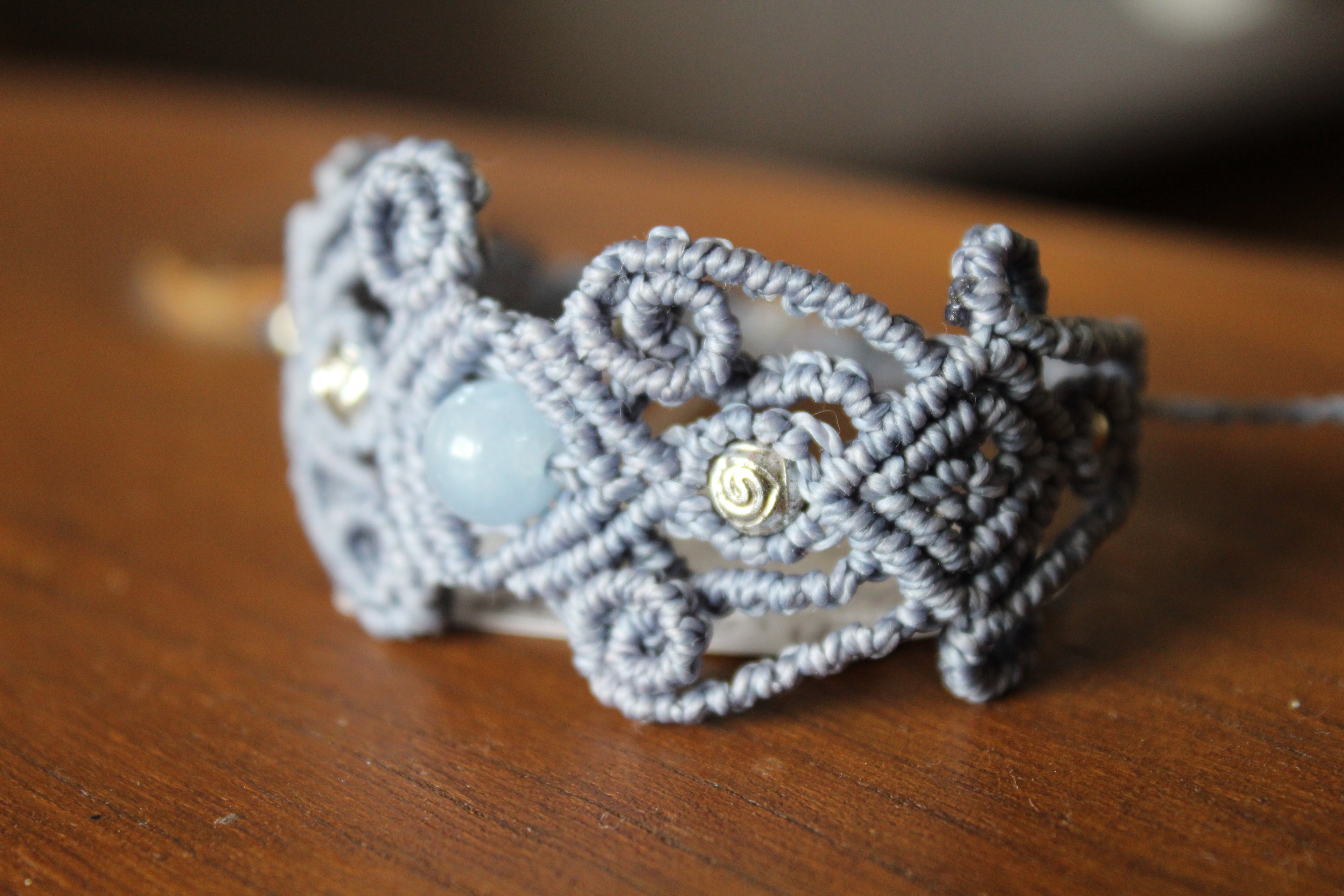 bracelet tissé a la main en micro macramé avec des perles en acrylique don 2 en forme de rose et une perle en aigue marine.