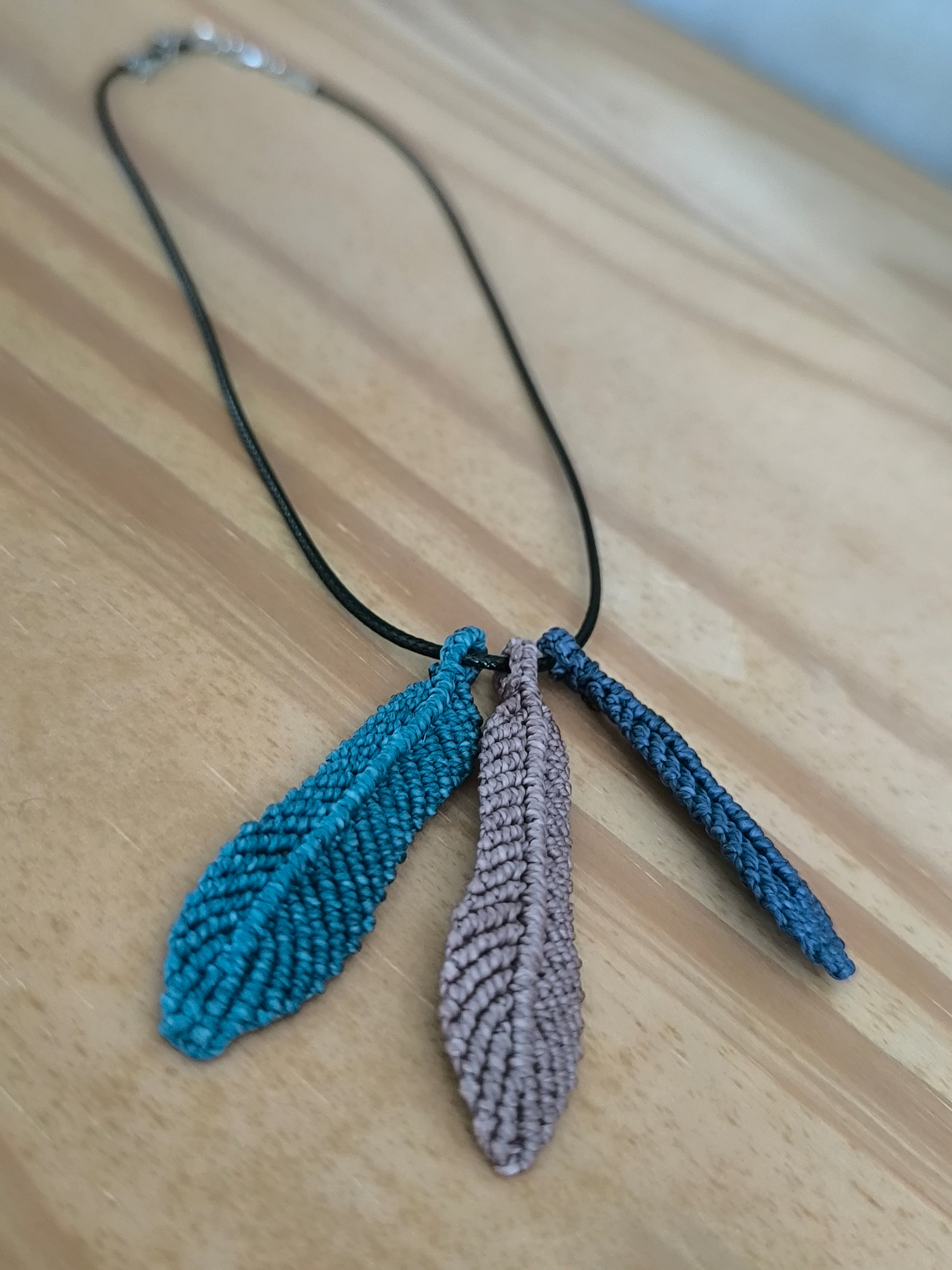 cordon en cuir noir avec trois plume tissé a la main en micro macramé.