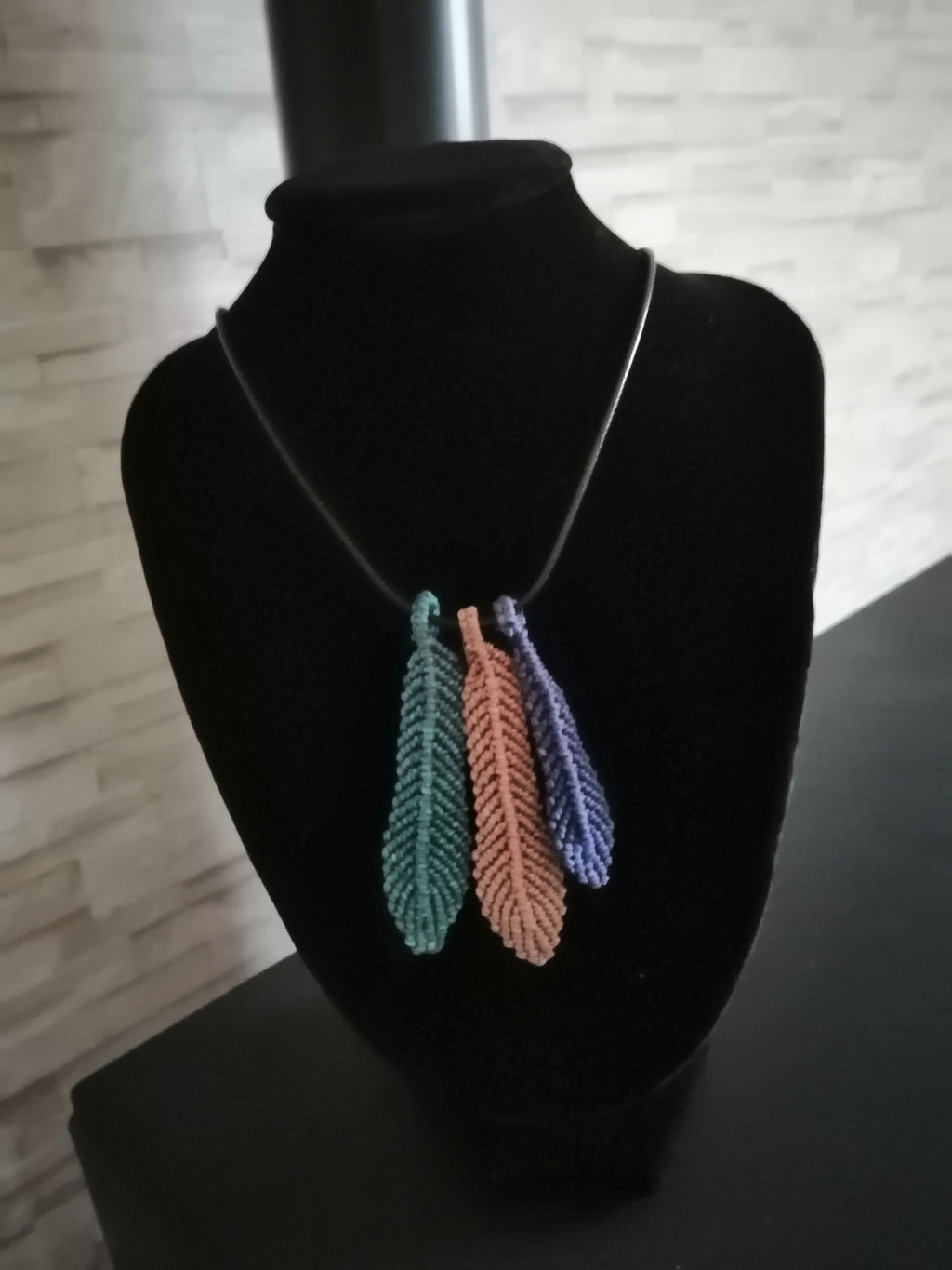 cordon en cuir noir avec trois plume tissé a la main n micro macramé.
