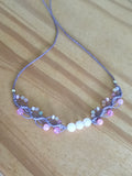 ras du cou de couleur mauve avec des perles en verre, des perles en acrylique fluorescentes et 3 perles en quartz rose .Tissé a la main en micro macramé.