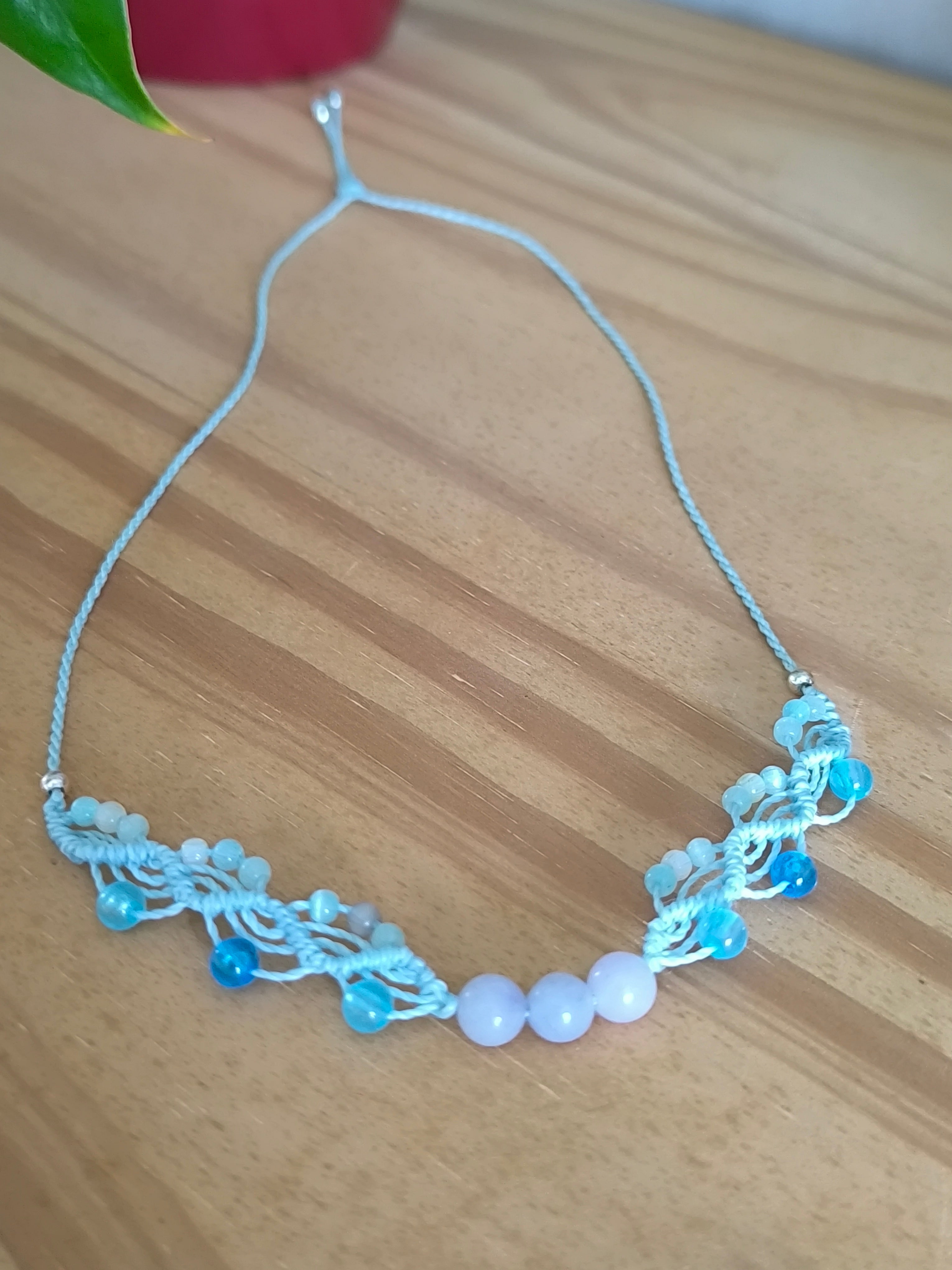 ras du cou de couleur azur clair avec des perles en verre, des perles en acrylique fluorescentes et 3 perles en aigue marine. Tissé a la main en micro macramé.