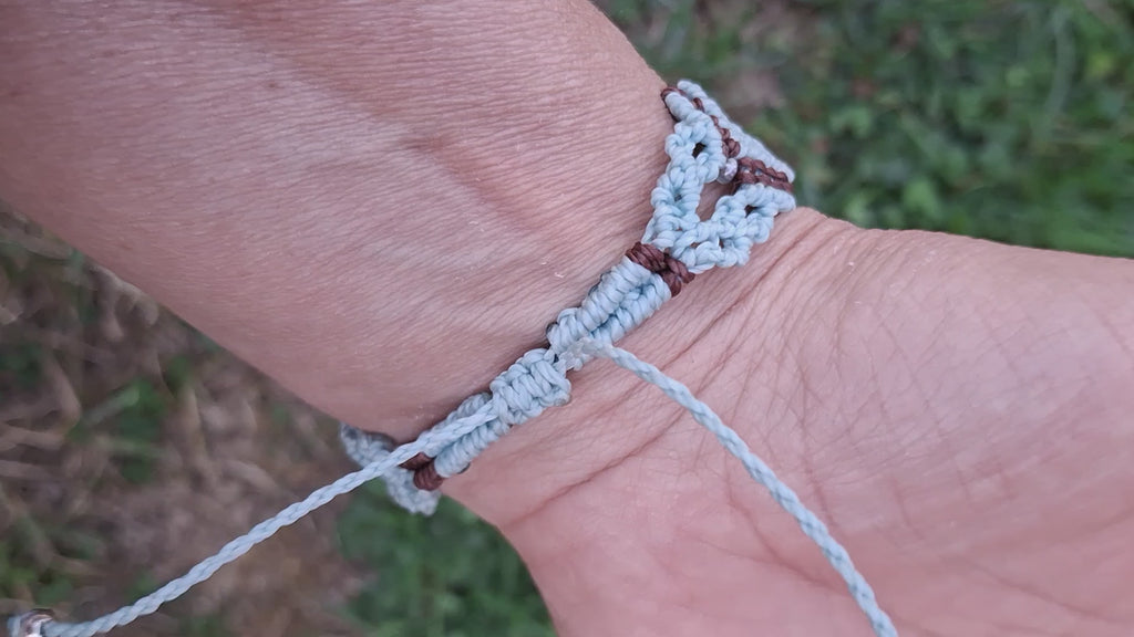 bracelet tissé à la main en micro macramé de couleur menthe et chocolat avec une perle fluorescente  en verre  bleu et des perles de rocailles fluorescente 